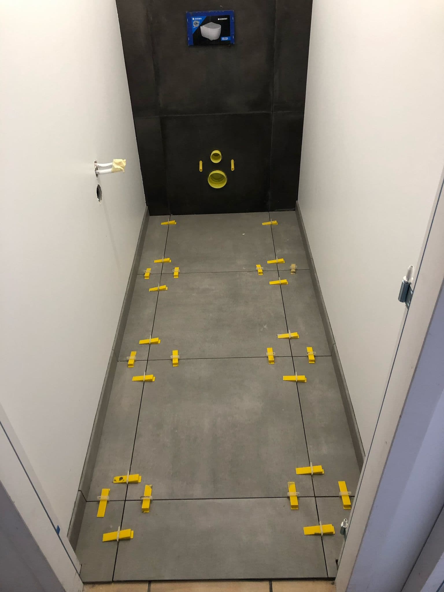 Pose de carrelage grand format dans un WC